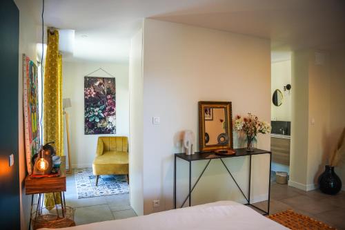 a room with a bed and a table and a chair at suite indépendante au calme avec piscine in Aix-en-Provence