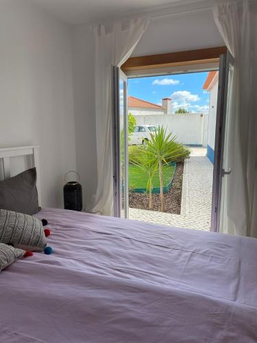 a bedroom with a bed and a door to a yard at Joia da Casa House with private Pool in Sobral