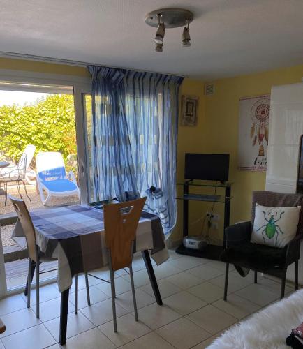 a dining room with a table and chairs and a window at Studio idéal 2 personnes côte de granit rose in Perros-Guirec