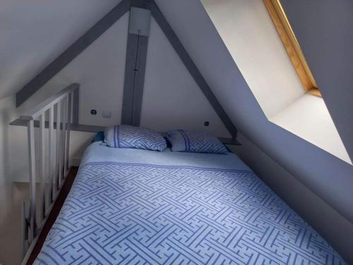 a bedroom with a bed in a attic at 17, face à la gare in Lannion