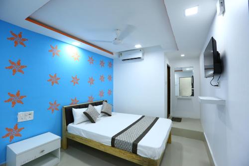 um quarto com uma cama e uma parede azul em HOTEL GOLDEN CITY em Surat
