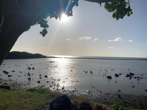 a view of a body of water with the sun shining at Azuri Apartment 8 in Roches Noires