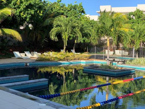 a swimming pool with palm trees in the water at Azuri Apartment 8 in Roches Noires