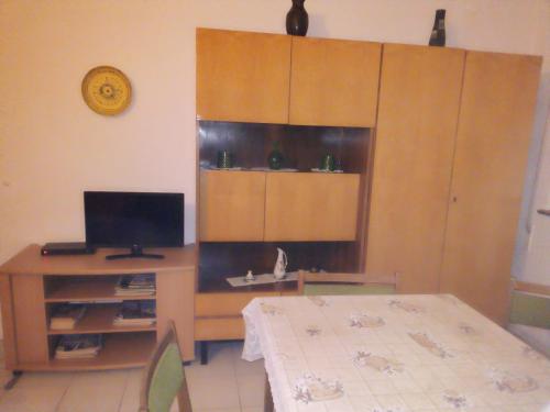 een kamer met een tafel en een bureau met een televisie bij Panoráma Pihenőház in Balatonalmádi