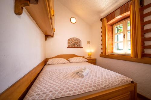 a bedroom with a bed with a stuffed animal on it at The Ultimate Escape - traditional cottage & private pool in Selca