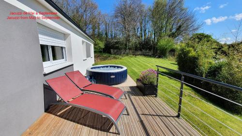 a deck with two chairs and a fire pit at Gîte des Hauts de Saint Jean in Saint-Jean-du-Doigt
