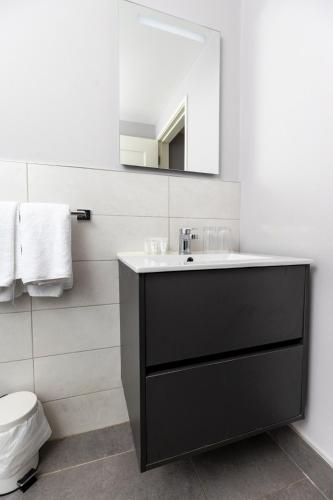 a bathroom with a black sink and a mirror at Bugler Doyles Bar & Townhouse in Wexford