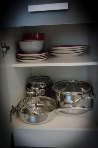 a kitchen shelf with dishes and plates on it at Lovely 2 bedroom apartment Lemon Grass in Central Lindau in Lindau