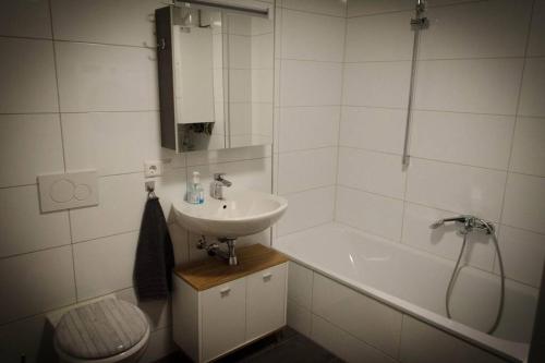 a white bathroom with a sink and a bath tub at Lovely 2 bedroom apartment Lemon Grass in Central Lindau in Lindau