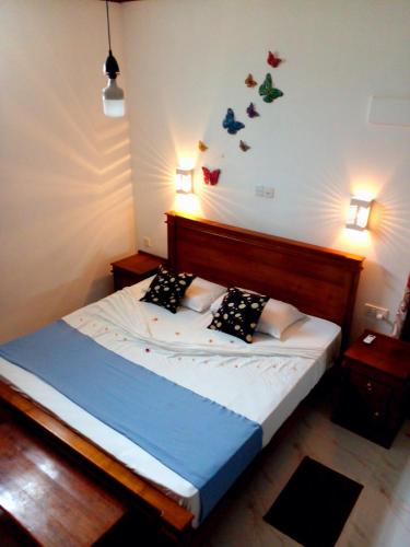a bedroom with a bed with butterflies on the wall at Sunils Inn Bentota in Bentota
