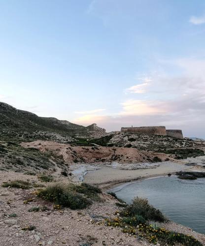 a body of water on a hill with a castle in the background at Casa Biank in Rodalquilar