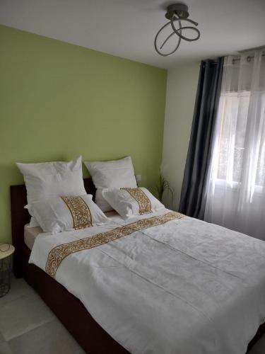 une chambre avec un grand lit avec des draps et des oreillers blancs dans l'établissement Petit Rêve des Corbières, à Durban-Corbières