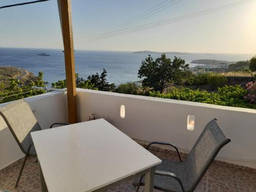 a white table and chairs on a balcony with the ocean at Silver view in Batsi