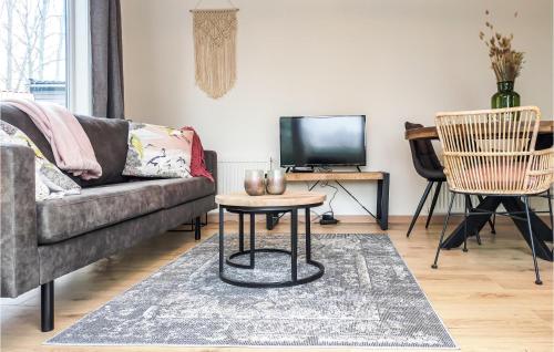 a living room with a couch and a table at Cozy Home In Heinkenszand With Kitchen in Heinkensand