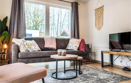 a living room with a couch and a tv at Cozy Home In Heinkenszand With Kitchen in Heinkensand