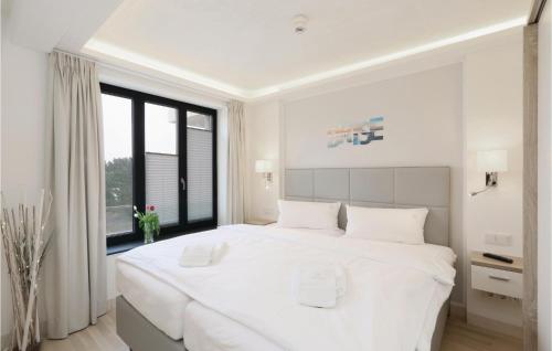 ein weißes Schlafzimmer mit einem großen weißen Bett und einem Fenster in der Unterkunft Princess in Binz