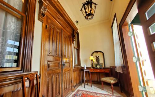 a hallway with a wooden door and a desk at 国重要文化財太刀川家洋館ゲストハウスTachikawa Familys House in Hakodate