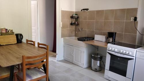 a kitchen with a table and a stove top oven at Les Amis de Beauval in Seigy