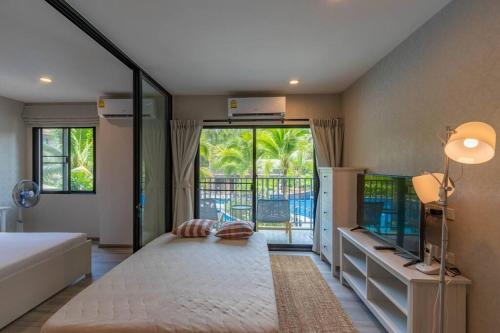 a bedroom with a large bed and a large window at Title Naiyang residence Excellent location with pool view in Nai Yang Beach