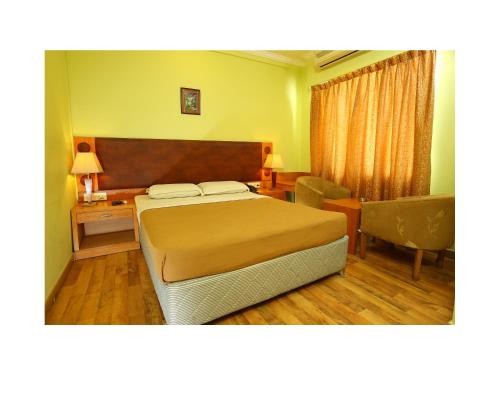 a bedroom with a bed and a desk and a chair at The Ocea International Hotel in Bangalore