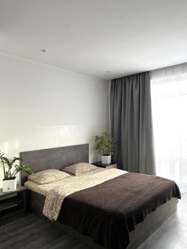 um quarto com uma cama grande e uma janela em Комфортні апартаменти 82 em Ivano-Frankivsʼk
