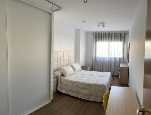 una piccola camera con letto e finestra di Apartamento El Azul a Molina de Segura
