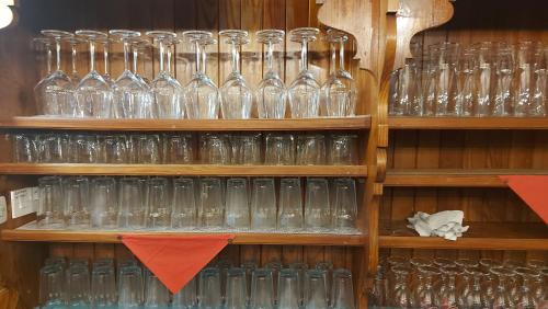 a shelf filled with glasses sitting on top at Tičarjev Dom at Vrsic pass in Soča