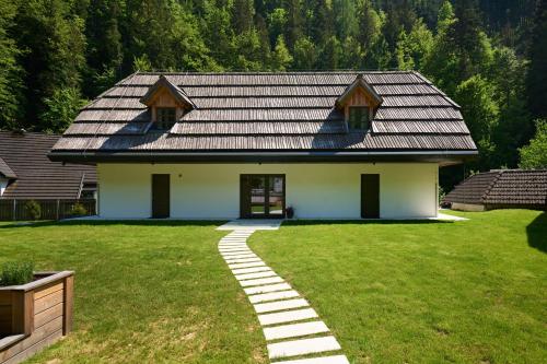 a house with a slate roof and a walkway at NATUR BAJTA in Solčava