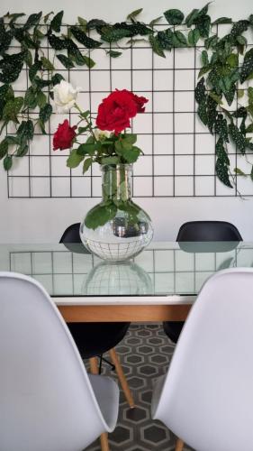 a vase of roses on a table with two chairs at Apartman L&M in Cetinje