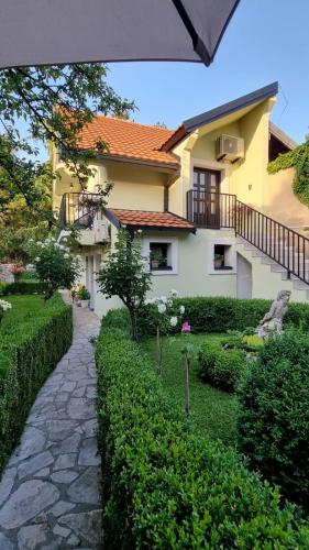 a house with a stone path in front of it at Apartman L&M in Cetinje