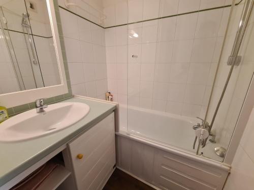 a bathroom with a sink and a shower and a tub at Echappée en altitude in La Mongie