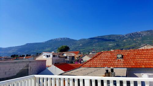 a city with orange roofs and mountains in the background at Croatian Stone House in Kaštela