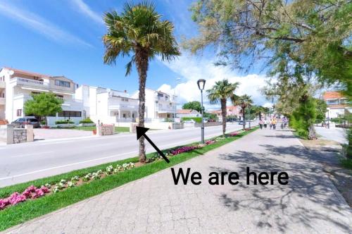 a street with a sign that says we are here at Apartment and Rooms Dalmatiko in Vodice