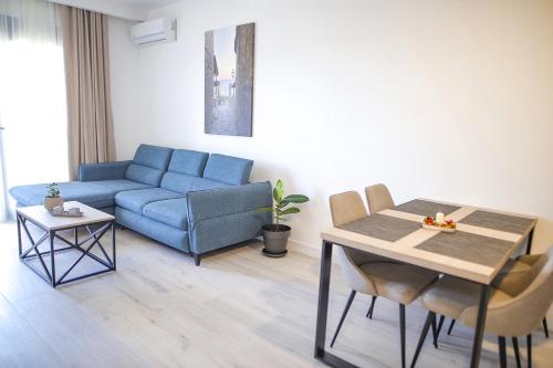 a living room with a blue couch and a table at Allure Apartments in Ulcinj