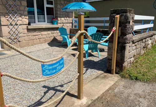 - une aire de jeux avec une corde, un parasol et des chaises dans l'établissement Le Balcon Bleu, gîte located in Millevaches National Park, à Chavanac