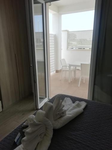 a pile of white towels sitting on top of a bed at Sabbia Bianca Affittacamere in Torre Lapillo