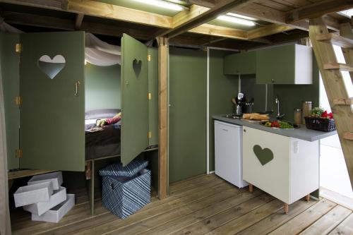 a kitchen with green walls and a bed in a room at Blu International Camping in Bolsena