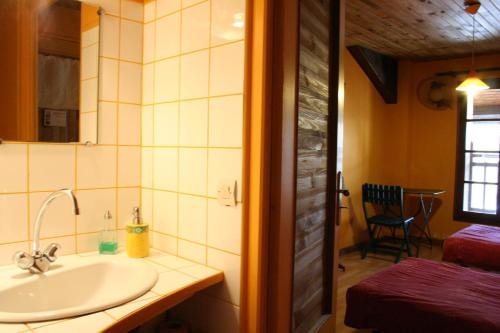 a bathroom with a sink and a room with a bed at Les Pascals in Saint-Paul-lès-Romans