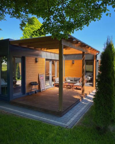 a pavilion with a deck in a yard at Resort 36 in Mikołajki