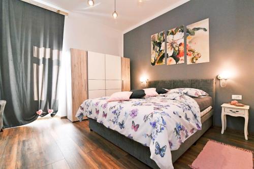 - une chambre dotée d'un lit avec un couvre-lit floral dans l'établissement Apartment Carissima-Direct on sea, Lovran-Opatija, à Lovran
