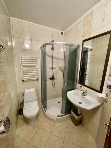 a bathroom with a shower and a toilet and a sink at Near the Lake in Lviv