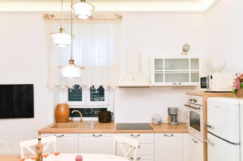 a kitchen with white cabinets and a sink at Apartment Carissima-Direct on sea, Lovran-Opatija in Lovran