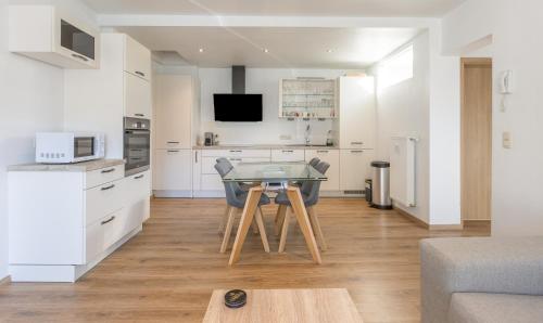 a kitchen with a table in the middle of a room at Appartement avec RoofTop au centre de Malmedy in Malmedy