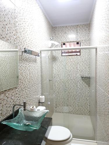 uma casa de banho com um chuveiro, um WC e um lavatório. em Pousada Quatro Estações em Alto Paraíso de Goiás