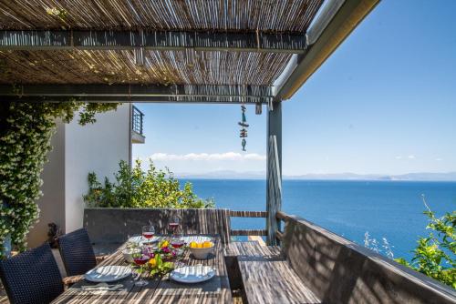 a table on a balcony with a view of the ocean at Sea Whisper Villa in Peloponnese in rkadiko Chorio