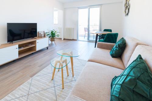 un salon avec un canapé et une télévision dans l'établissement LES LUCIOLES - Studio - Carré d'or Menton, à Menton