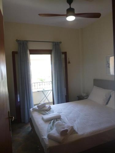 a bedroom with a bed with towels and a window at Orange Garden in Kala Nera