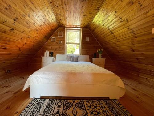 a bedroom with a large bed in a attic at Domek letniskowy Sosenka in Woryty