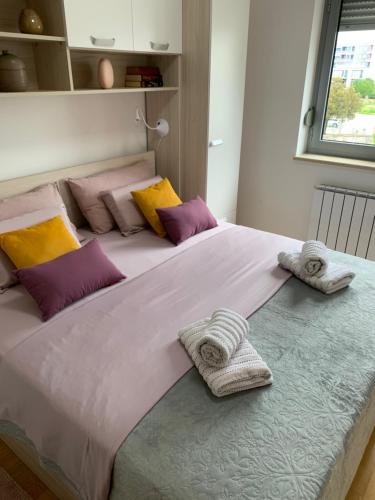 ein großes weißes Bett mit Handtüchern darüber in der Unterkunft Apartment Angela with private garage slot in Pula