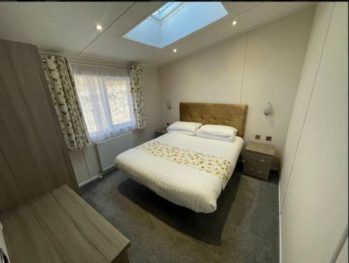 a bedroom with a large bed with a skylight at C05 - The Ogwen Lodge with Hot Tub in Bethesda